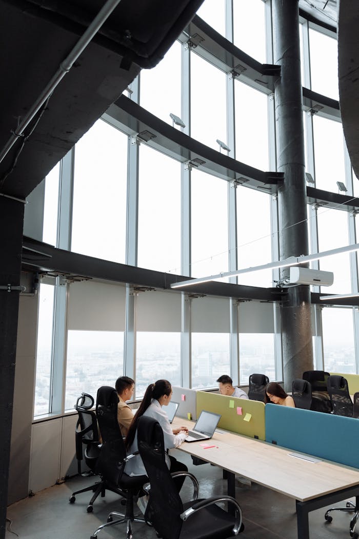 Spacious contemporary office space with employees working on laptops in a high-rise building.